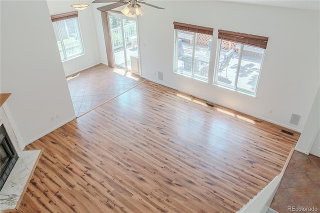 7978 S Johnson Ct, Littleton, CO 80128 - unfurnished living room with wood finished floors, a premium fireplace, and a ceiling fan