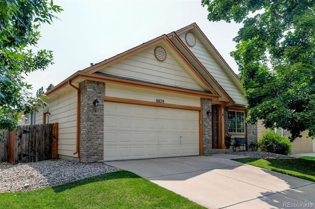8829 S Dudley St, Littleton, CO 80128 - view of front of property with concrete driveway, a garage, and brick siding