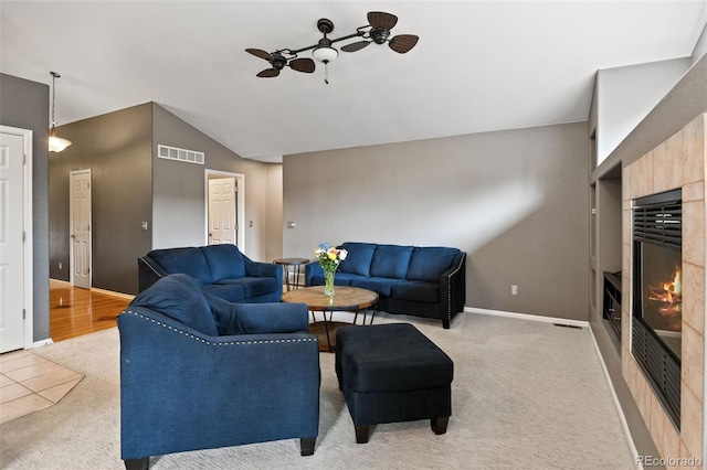 8829 S Dudley St, Littleton, CO 80128 - living area featuring a glass covered fireplace, vaulted ceiling, and light carpet