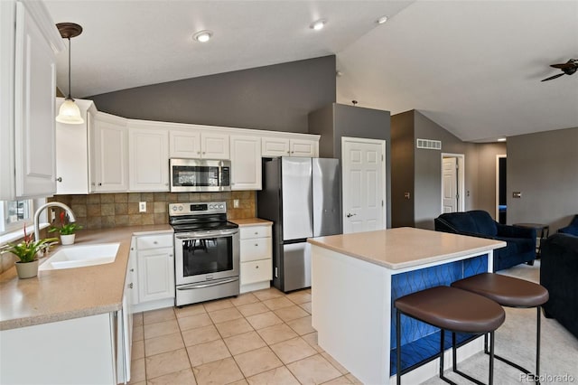 8829 S Dudley St, Littleton, CO 80128 - kitchen featuring appliances with stainless steel finishes, open floor plan, tasteful backsplash, a center island, and light countertops