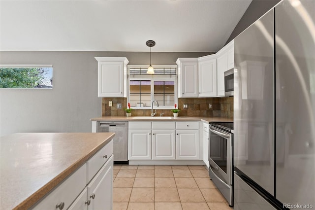 8829 S Dudley St, Littleton, CO 80128 - kitchen with appliances with stainless steel finishes, decorative backsplash, white cabinets, light tile patterned flooring, and vaulted ceiling