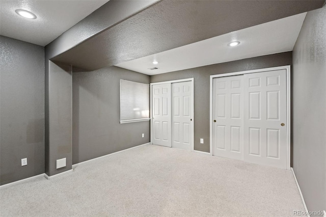 8829 S Dudley St, Littleton, CO 80128 - unfurnished bedroom featuring two closets, carpet flooring, recessed lighting, and a textured ceiling