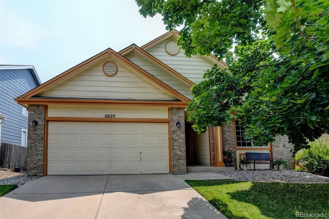 8829 S Dudley St, Littleton, CO 80128 - view of front of house featuring driveway, brick siding, and a garage