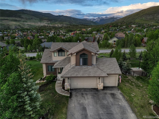 70 Lone Wolf Ct, Dillon, CO 80435 - view of front facade featuring asphalt driveway, a mountain view, stone siding, a front lawn, and a residential view