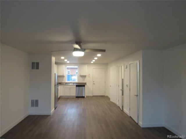 unfurnished living room featuring dark wood-type flooring, ceiling fan, and sink