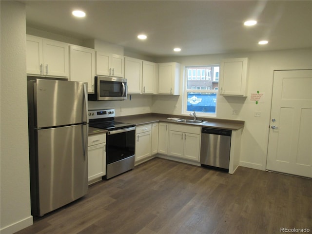 kitchen featuring white cabinets, stainless steel appliances, dark hardwood / wood-style floors, and sink