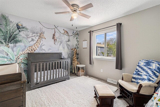 carpeted bedroom with a textured ceiling and ceiling fan