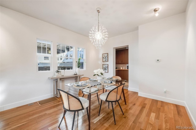 dining area with a notable chandelier and light wood-type flooring