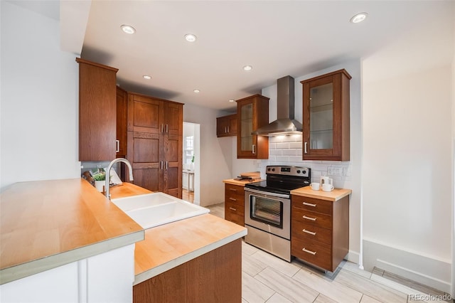 kitchen featuring sink, stainless steel electric range oven, decorative backsplash, kitchen peninsula, and wall chimney exhaust hood