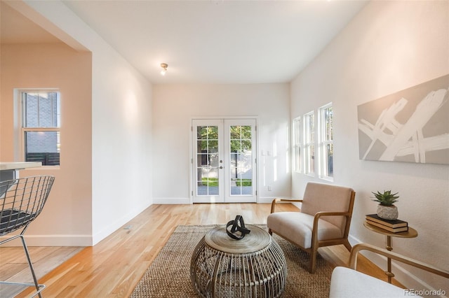 living area with light hardwood / wood-style floors and french doors