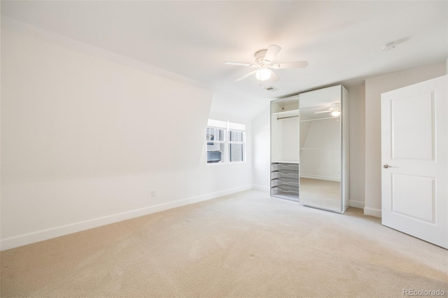 unfurnished bedroom with ceiling fan, a closet, and light carpet