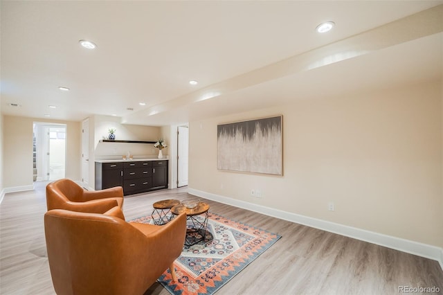 living room featuring light hardwood / wood-style floors and indoor bar