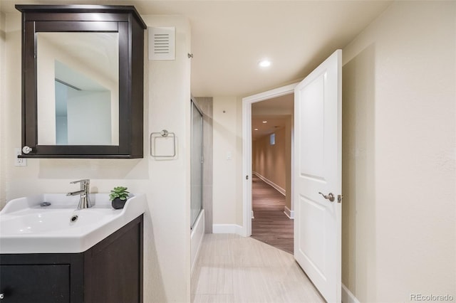 bathroom with vanity and shower / bath combination with glass door