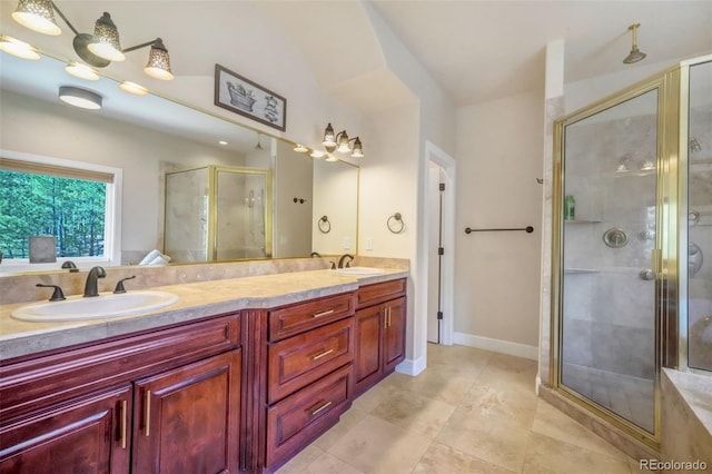 bathroom featuring a stall shower, double vanity, a sink, and tile patterned floors