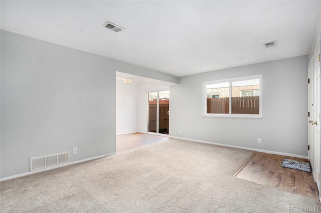 spare room featuring a textured ceiling and light hardwood / wood-style flooring