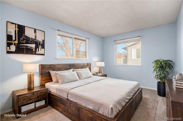 bedroom with light colored carpet and multiple windows