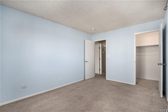 unfurnished bedroom with light colored carpet, a textured ceiling, and a closet