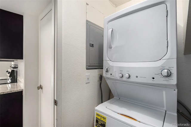 washroom with electric panel and stacked washer and clothes dryer