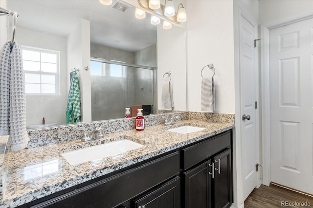 239 S Old Hammer St, Aurora, CO 80018 - full bathroom featuring a shower stall, double vanity, and wood finished floors