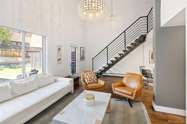 505 Detroit St, Denver, CO 80206 - living room featuring a high ceiling, stairway, wood finished floors, a baseboard heating unit, and a chandelier