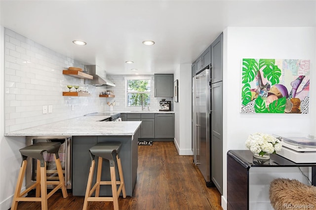 505 Detroit St, Denver, CO 80206 - kitchen with gray cabinets, a peninsula, tasteful backsplash, wall chimney range hood, and dark wood finished floors