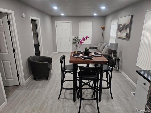 dining area featuring recessed lighting, baseboards, and light wood finished floors