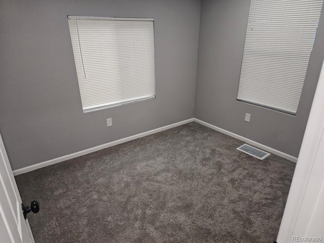 carpeted spare room featuring baseboards and visible vents