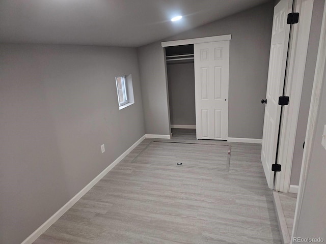 unfurnished bedroom featuring baseboards, light wood-style flooring, and a closet
