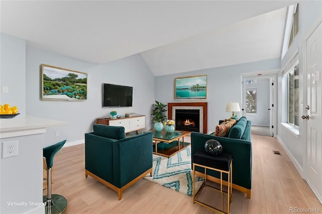 living room with vaulted ceiling and light wood-type flooring