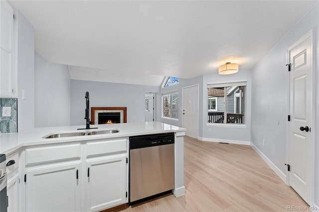 kitchen featuring sink, white cabinets, stainless steel dishwasher, and lofted ceiling