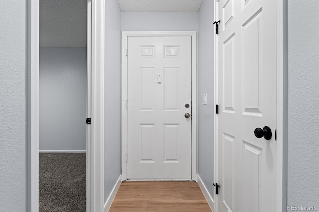 entryway featuring a textured ceiling and light hardwood / wood-style floors