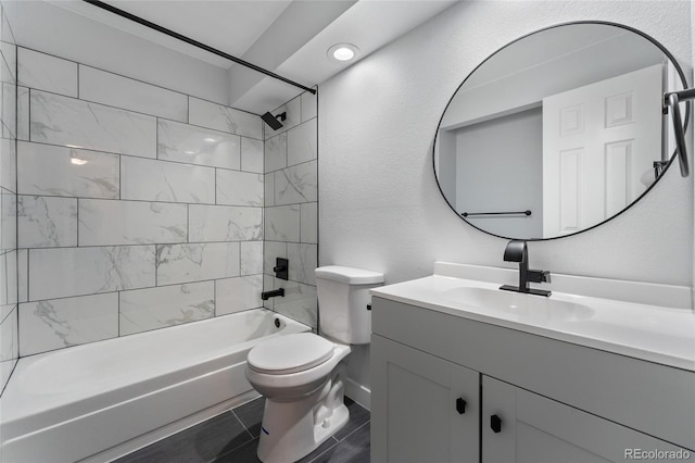 full bathroom featuring tiled shower / bath combo, vanity, and toilet