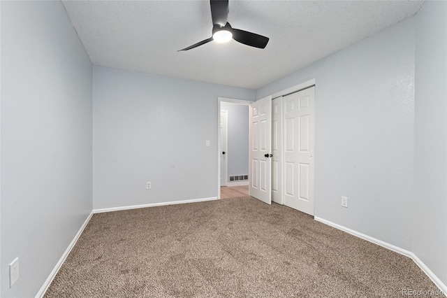 unfurnished bedroom featuring a textured ceiling, ceiling fan, and carpet flooring