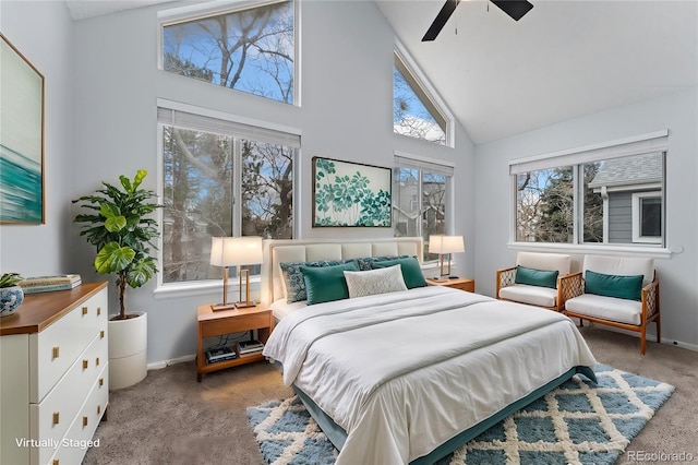 carpeted bedroom with ceiling fan and high vaulted ceiling