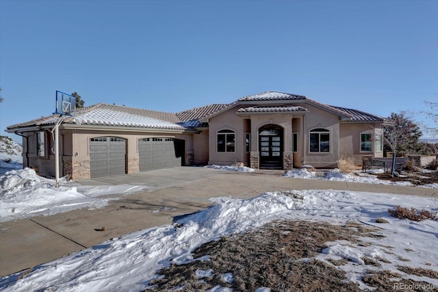 mediterranean / spanish house with a garage and french doors