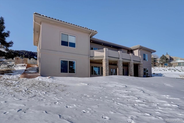 view of snow covered back of property