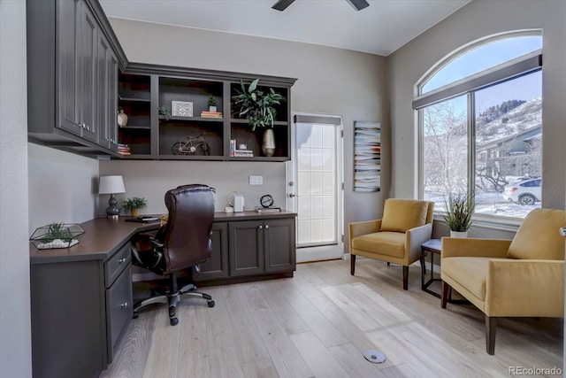 office area featuring built in desk, light hardwood / wood-style floors, and ceiling fan