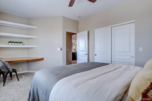 carpeted bedroom featuring built in desk, ceiling fan, and a closet