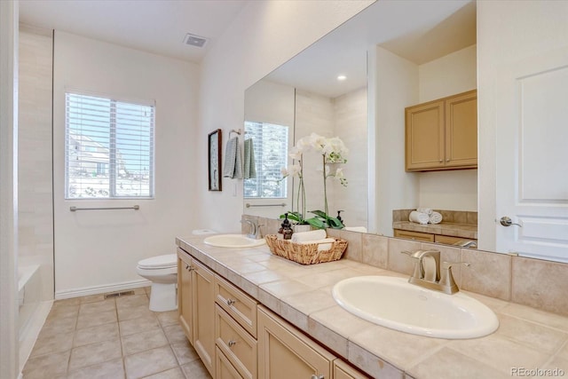 bathroom with vanity, a bath, tile patterned floors, and toilet