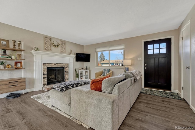 living room featuring a fireplace, wood finished floors, and baseboards