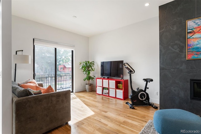 living room featuring recessed lighting, baseboards, and light wood finished floors