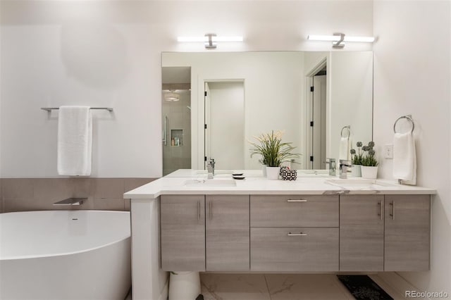 full bath featuring marble finish floor, double vanity, a soaking tub, an enclosed shower, and a sink