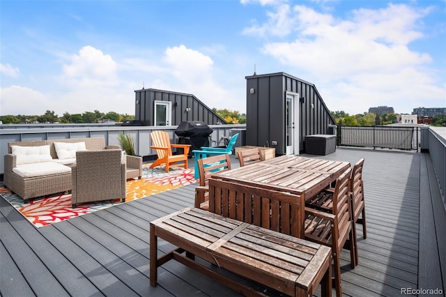 deck featuring outdoor dining space, a grill, an outbuilding, and an outdoor hangout area