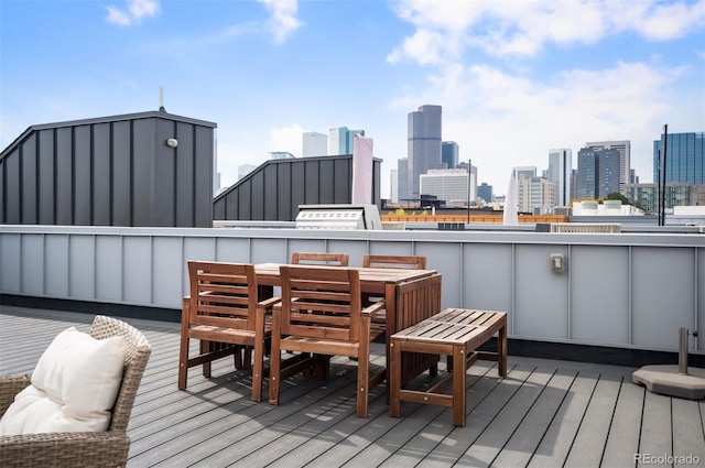 wooden terrace with a view of city and outdoor dining space