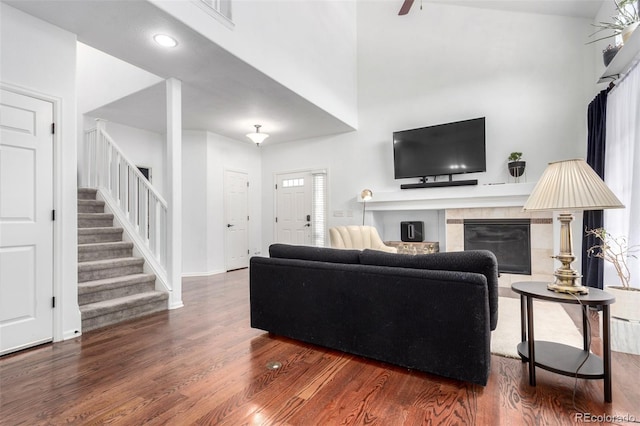 4712 Raven Run, Broomfield, CO 80023 - living room with a tiled fireplace, visible vents, baseboards, wood finished floors, and stairway