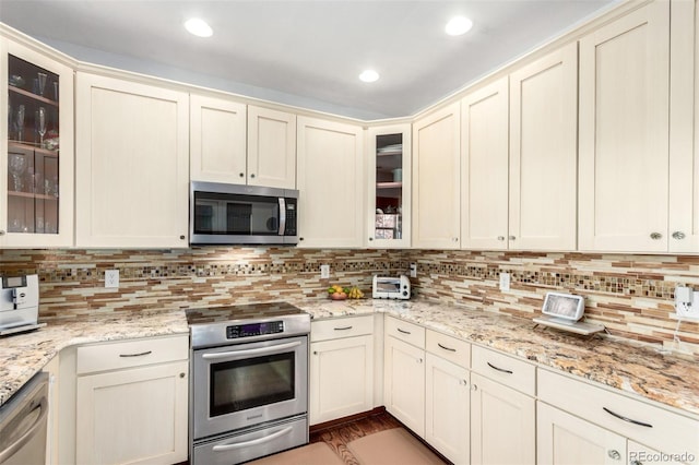 4712 Raven Run, Broomfield, CO 80023 - kitchen with backsplash, glass insert cabinets, light stone counters, and stainless steel appliances