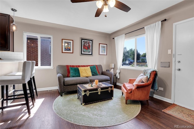 living room with ceiling fan and dark wood-type flooring