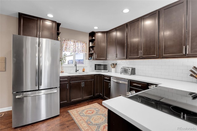 kitchen featuring dark hardwood / wood-style floors, dark brown cabinetry, sink, and stainless steel appliances