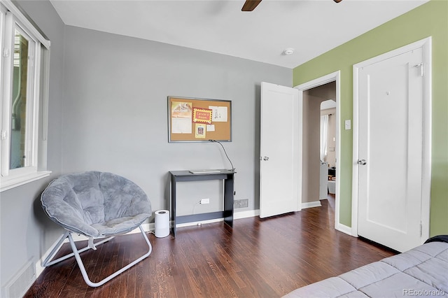 living area featuring dark hardwood / wood-style flooring and ceiling fan