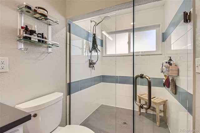 bathroom with a shower with shower door and toilet